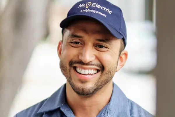 Close-up of the head and shoulders of a smiling Mr. Electric service professional wearing a blue Mr. Electric hat