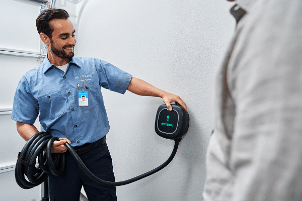 Mr. Electric service professional installing EV charger in customer's garage.