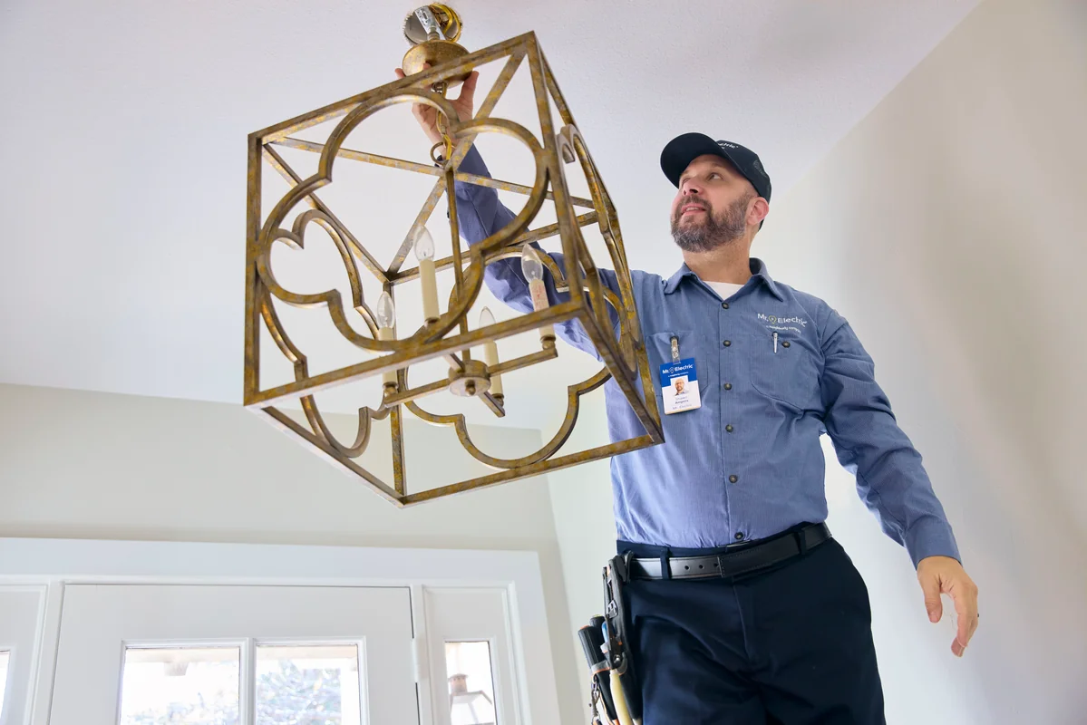 Mr. Electric service professional installing a ceiling light fixture