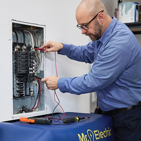 Professional electrician performing a home electrical panel inspection and maintenance