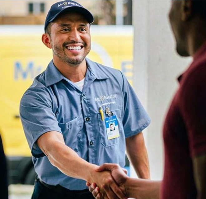 MRE electrician greeting a family at their door.