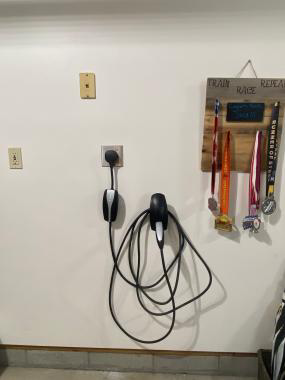 An electrical vehicle charger installed in a garage.