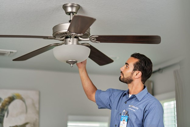 Electrician adjusting ceiling fan