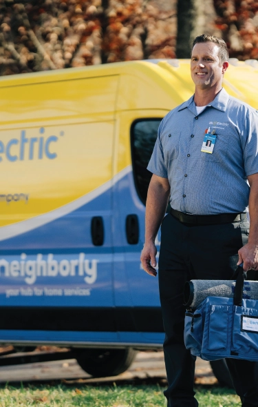 Male electrician standing in front of Mr. Electric branded van.