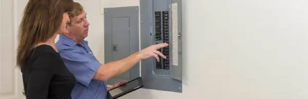 Mr. Electric Technician Inspecting Electrical Panel With Customer.