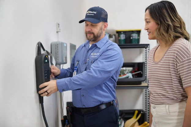 MRE Technician installing an electric vehicle charging station in a utility room.