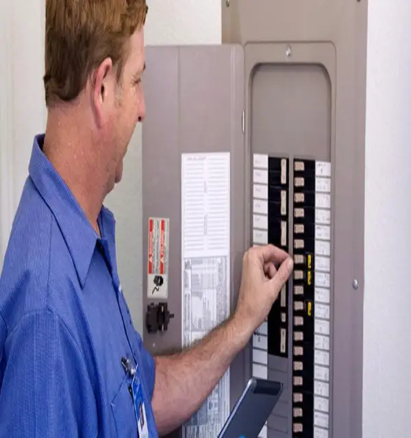 An electrician inspecting a breaker panel that has been recently installed with electrical panel upgrade services.