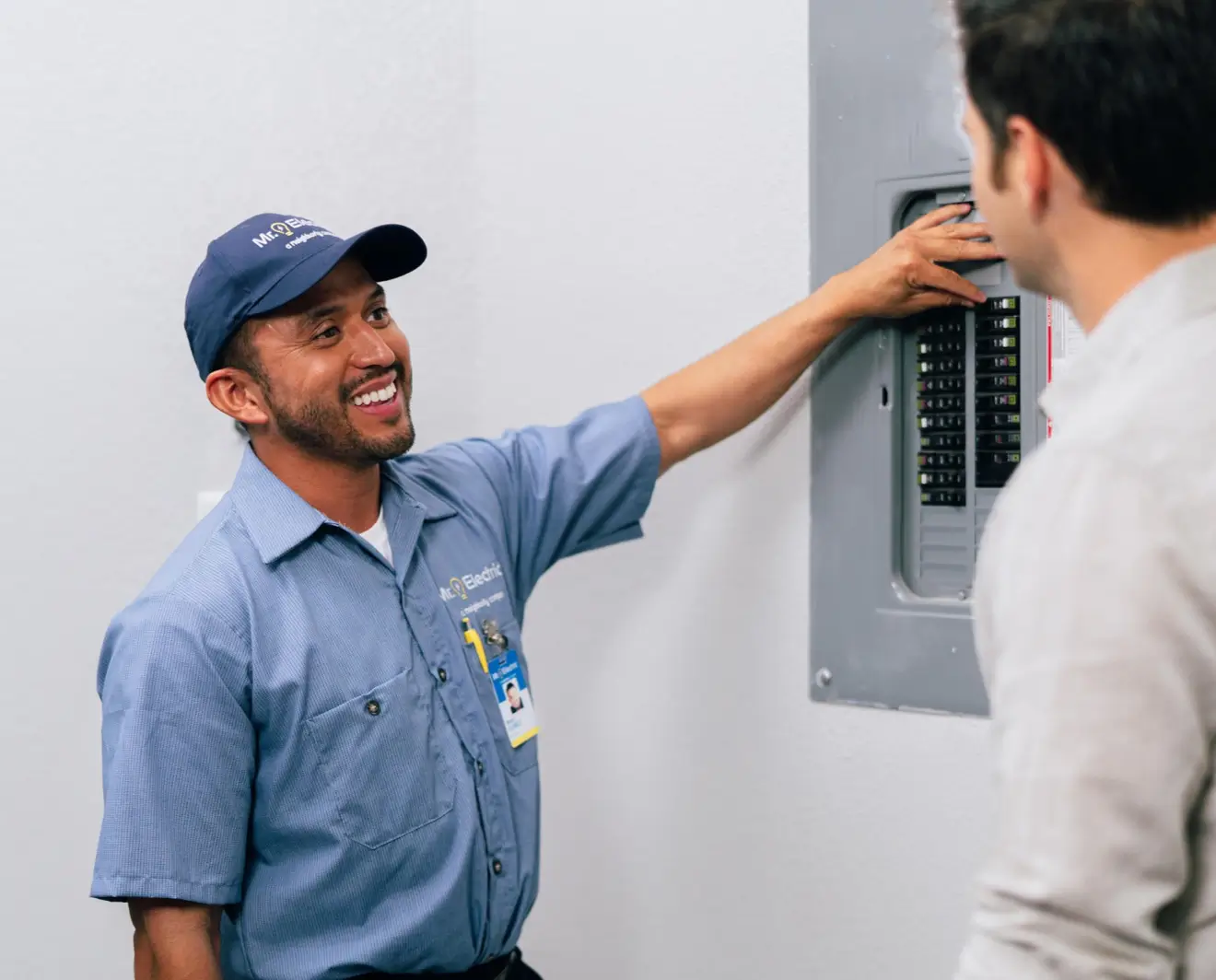 Mr. Electric technician showing electric panel to customer.