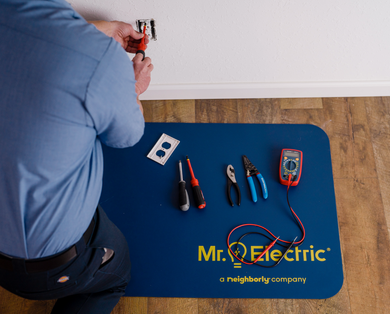 Mr. Electric technician working on outlet.