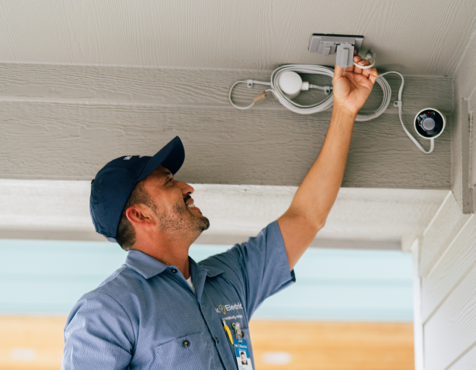 Mr. Electric technician installing outdoor security camera.