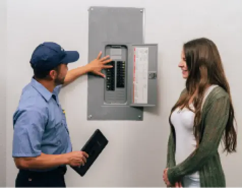 Mr. Electric technician showing subpanel to customer.