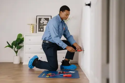 An electrician performs outlet repairs