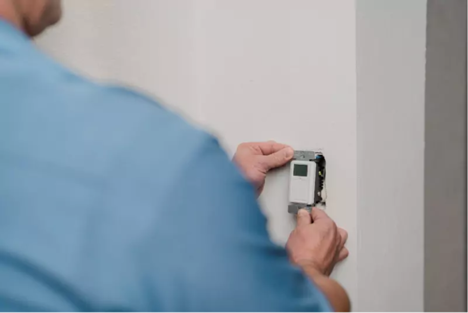 A Mr. Electric electrician installing a light timer switch