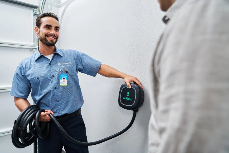 Mr. Electric electrician discussing an EV charger installation with a client