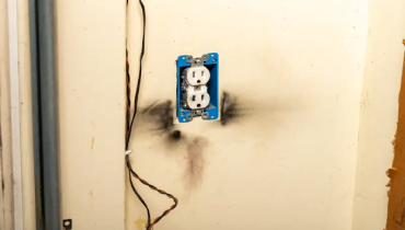 A burnt wall and electrical outlet.