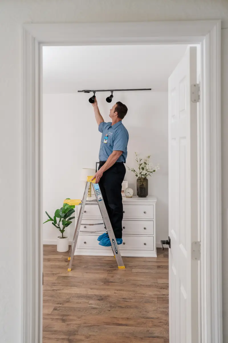 A Mr. Electric service professional installing lights.