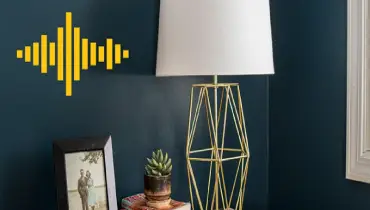 A table with a lamp and a photo frame on it.