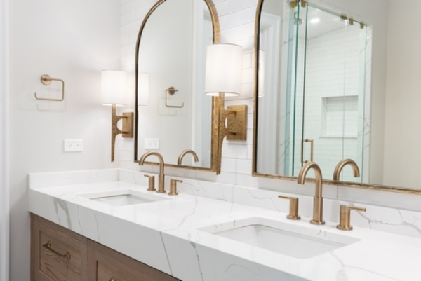 Clean, modern bathroom with soft sconce lights on either side of the mirror.