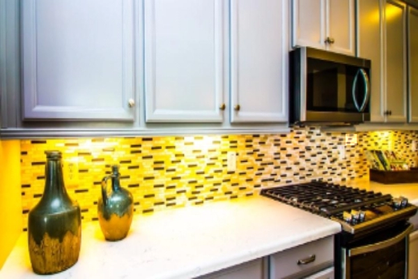 Modern kitchen with yellow tile backsplash and white cabinets