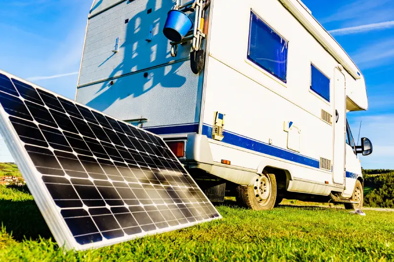 A close-up of a solar panel next to an RV.