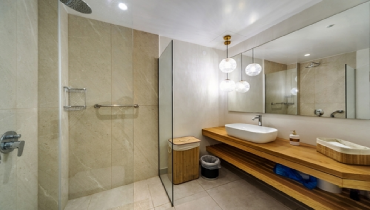 Well-lit windowless bathroom with a modern design and globe lights hanging over the sink.