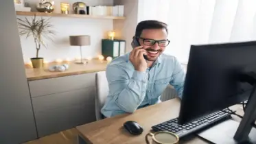 man on the phone at home office desk