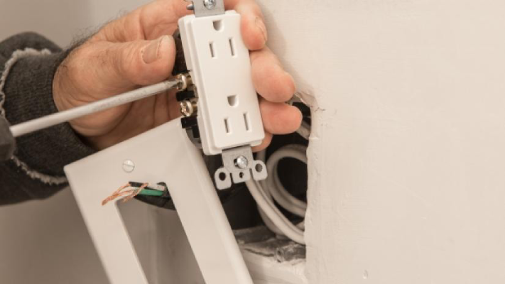 Person preparing to install an electric wall outlet