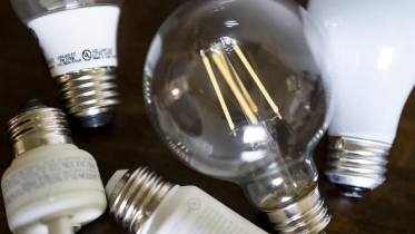 A group of light bulbs on top of a wooden table.